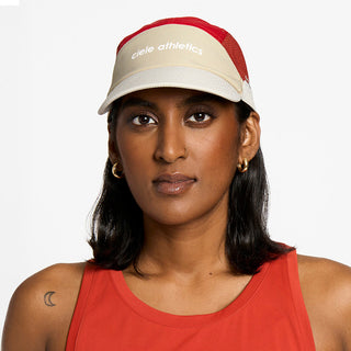 front view of the ciele athletics FTSCap unisex running hat in safari red color, on a model