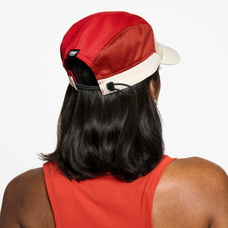 back view of the ciele athletics FTSCap unisex running hat in safari red color, on a model