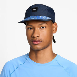 front view of the ciele athletics GOCap unisex running hat in indigo color, on a model
