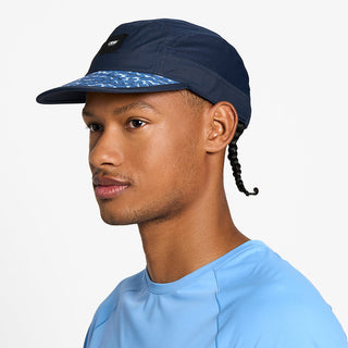 side view of the ciele athletics GOCap unisex running hat in indigo color, on a model