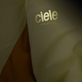 closeup view of the reflective sleeve logo of the ciele athletics VNTJacket lightweight running jacket for men in glade color, when reflective