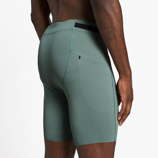 side view of ciele athletics FSTTight 8 inch short running tight in silver pine on a model