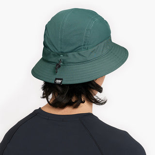 back view of ciele athletics GOBucket Comp Athletics unisex running bucket hat in silverpine color on a model