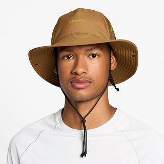 front view of the ciele athletics TRLBucket unisex running bucket hat in dark ochre color, on a model