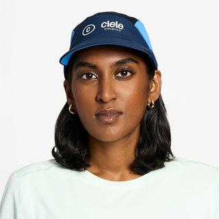 front view of the ciele athletics FTSCap unisex running hat with a curved brim in indigo color, on a model