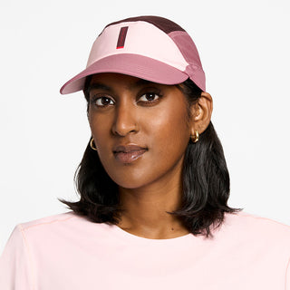 front view of the ciele athletics FTSCap unisex running hat with a curved brim in peachskin color, on a model