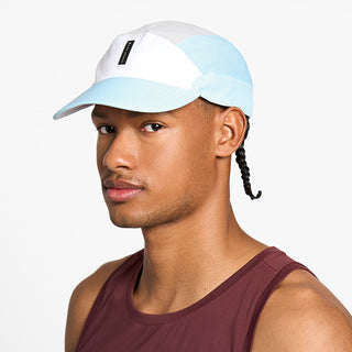 side view of the ciele athletics FTSCap unisex running hat with a curved brim in white color, on a model