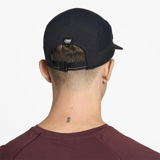 back view of ciele athletics GOCap Comp Bars unisex running hat in shadowcast color on a model