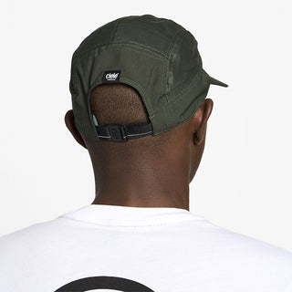 back view of ciele athletics GOCap Comp Bars unisex running hat in dark ochre color on a model