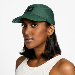 front view of the ciele athletics FTSCap unisex running hat with a curved brim in emerald color, on a model