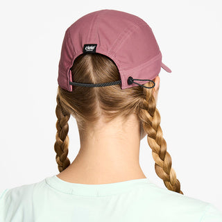 back view of the ciele athletics FTSCap unisex running hat with a curved brim in deco rose color, on a model