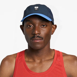 front view of ciele athletics GOCap Comp C cube unisex running hat in indigo color on a model