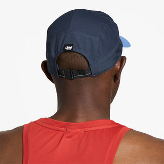 back view of ciele athletics GOCap Comp C cube unisex running hat in indigo color on a model