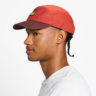 side view of the ciele athletics GOCap with a curved brim unisex running hat in clay color, on a model