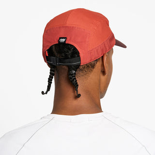 back view of the ciele athletics GOCap with a curved brim unisex running hat in clay color, on a model
