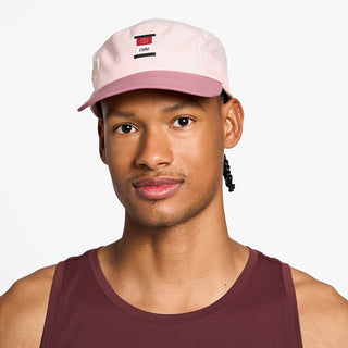 front view of the ciele athletics GOCap with a curved brim unisex running hat in peachskin color, on a model