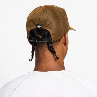 back view of the ciele athletics TRLCap unisex running hat with a curved brim in dark ochre color, on a model