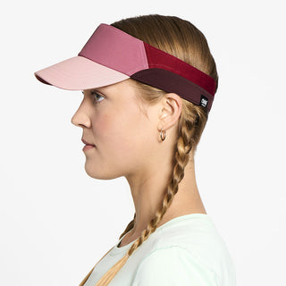 side view of ciele athletics FSTCap Comp Iconic VC unisex running hat in deco rose color on a model