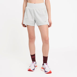 person wearing light gray athletic shorts and brick socks on a white background