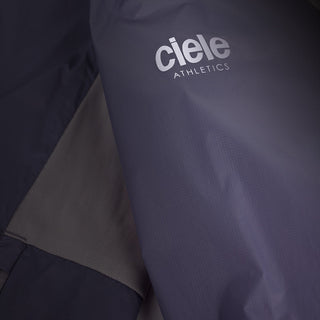 closeup view of the reflective sleeve logo of the ciele athletics VNTJacket lightweight running jacket for women in grape color, when reflective