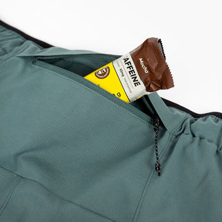 close view of the zippered back pocket of the ciele athletics DLYShort 4 inch with a long brief in silver pine color